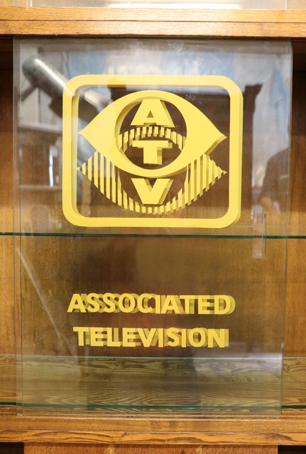  A 1930s/ 1940s oak bookcase or display cabinet decorated with the Associated Television logo. View VII