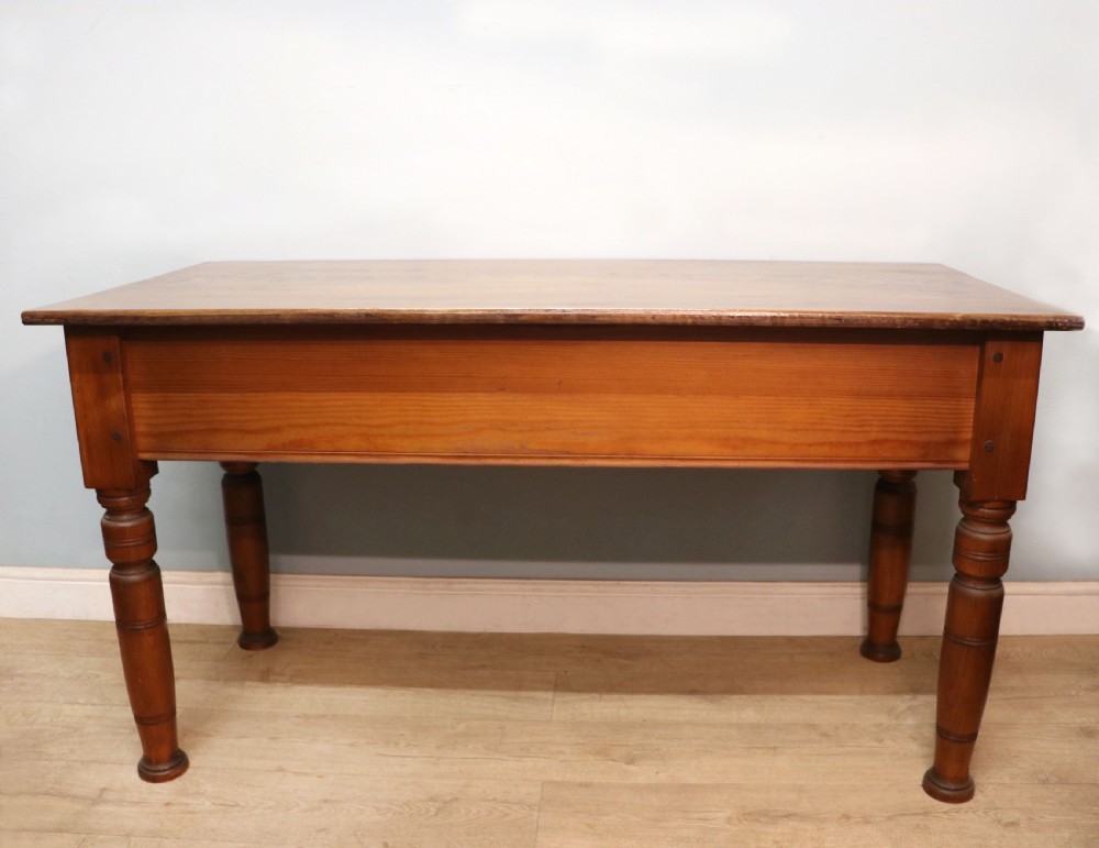 A Victorian stained pine table featuring an elm top and turned legs, shown against a plain background.