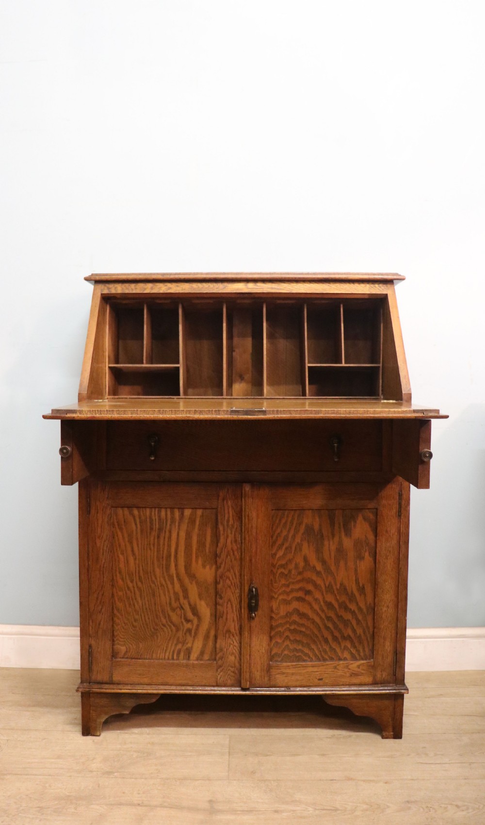 A late Victorian oak bureau in the Arts and Crafts style. 