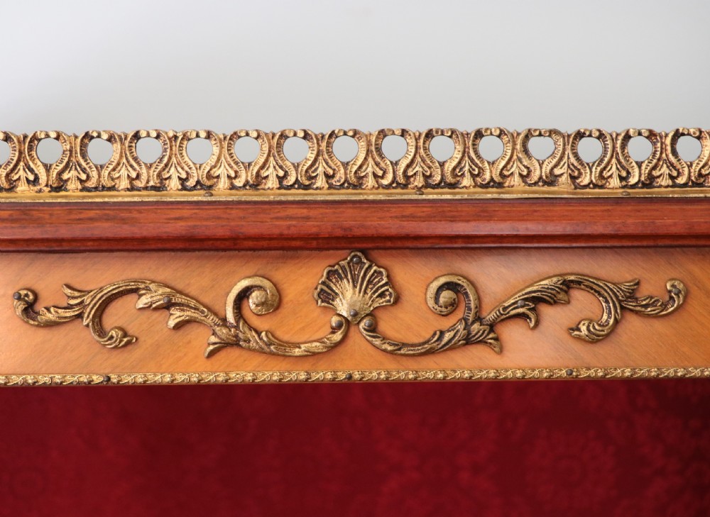 A French Vernis Martin style mahogany vitrine cabinet featuring a brass top gallery, glass shelves, red fabric lining, and a glazed door with gilded lettering. View XI