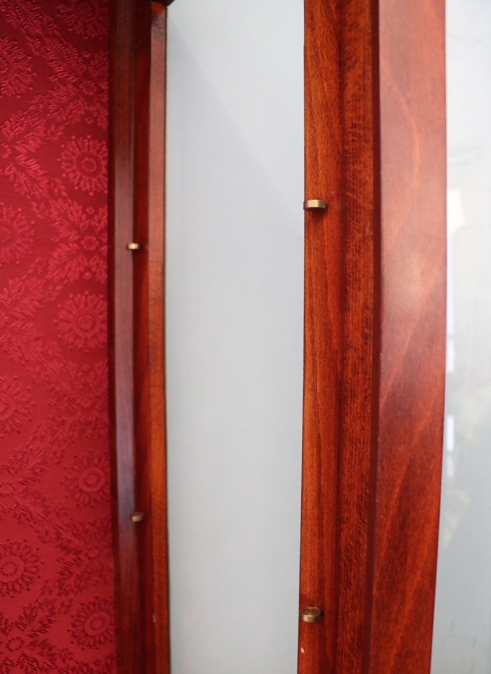 A French Vernis Martin style mahogany vitrine cabinet featuring a brass top gallery, glass shelves, red fabric lining, and a glazed door with gilded lettering. View XXVI