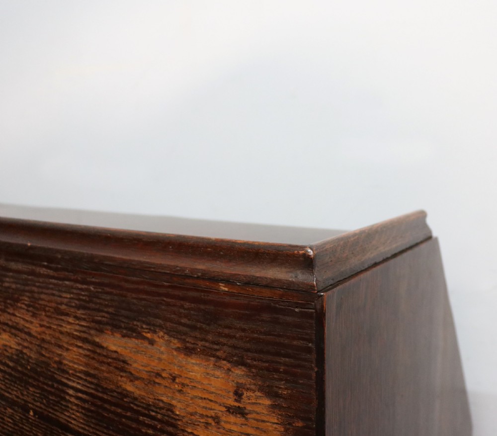 A dark oak fall-front bureau with octagonal geometric cupboard doors, carved details, turned gadrooned feet, and an open fitted stationery compartment. View XXIII