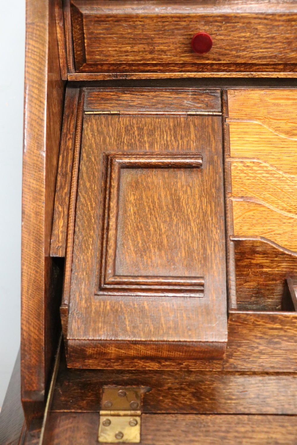 A dark oak fall-front bureau with octagonal geometric cupboard doors, carved details, turned gadrooned feet, and an open fitted stationery compartment. View XXIV