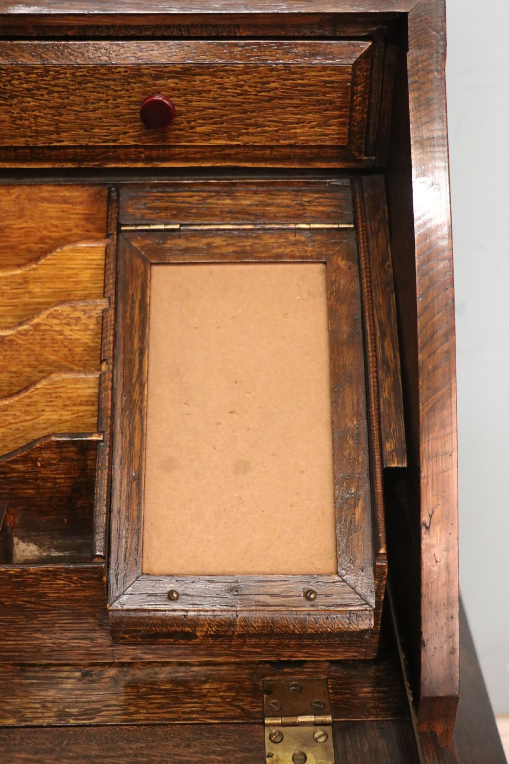 A dark oak fall-front bureau with octagonal geometric cupboard doors, carved details, turned gadrooned feet, and an open fitted stationery compartment. View XXVII