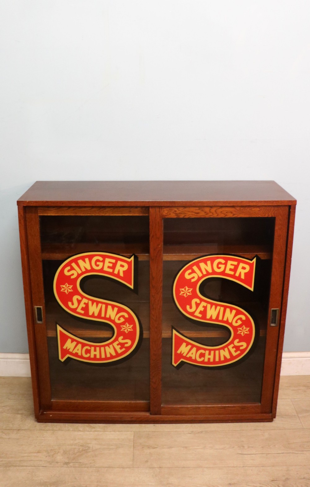 A lovely early 20th century oak framed display cabinet sign written for Singer Sewing Machines.