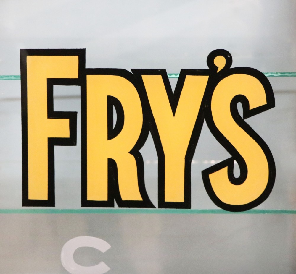 A pair of early 20th-century wooden glazed counter display cabinets featuring sign-written Frys Chocolate lettering on the front glass panels and interior glass shelves. View XII