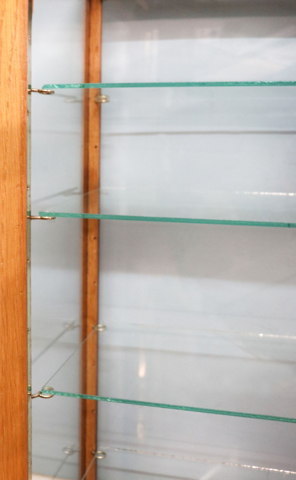 A pair of early 20th-century wooden glazed counter display cabinets featuring sign-written Frys Chocolate lettering on the front glass panels and interior glass shelves. View XVI