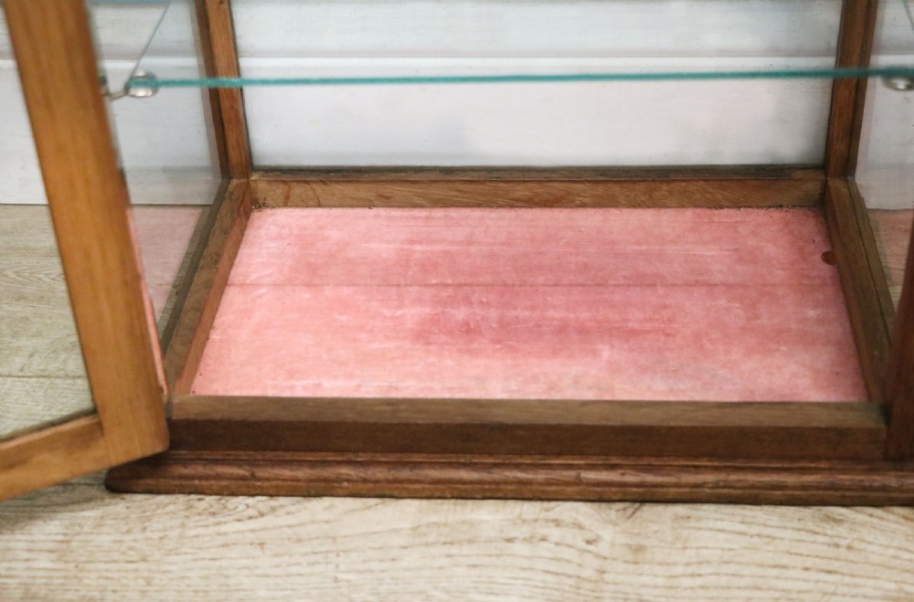 A pair of early 20th-century wooden glazed counter display cabinets featuring sign-written Frys Chocolate lettering on the front glass panels and interior glass shelves. View XVIII