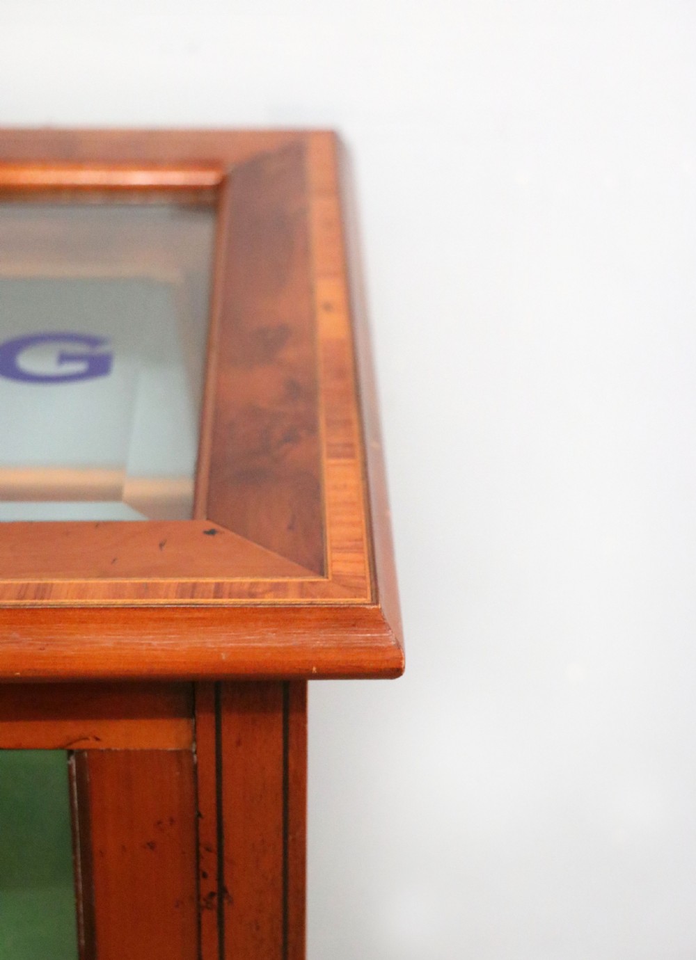 A glazed yew wood bijouterie display table featuring a green velvet interior lining, lower undertier, and Breitling 1884 logo printed on the top glass. View IX