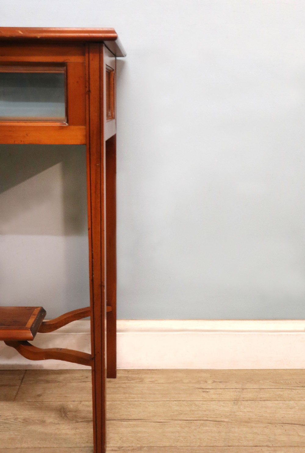 A glazed yew wood bijouterie display table featuring a green velvet interior lining, lower undertier, and Breitling 1884 logo printed on the top glass. View XIII