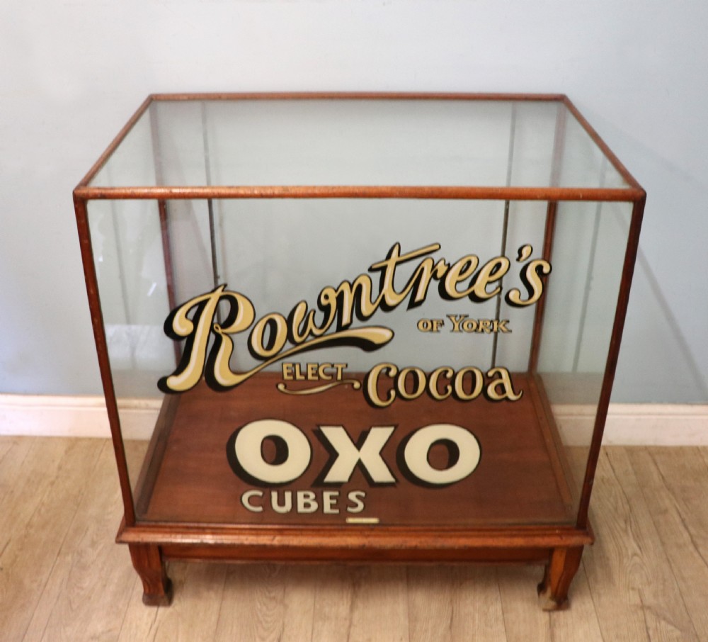 A glazed hardwood countertop display cabinet with sign-written lettering for Rowntrees Elect Cocoa and OXO Cubes on the front glass panel. View II