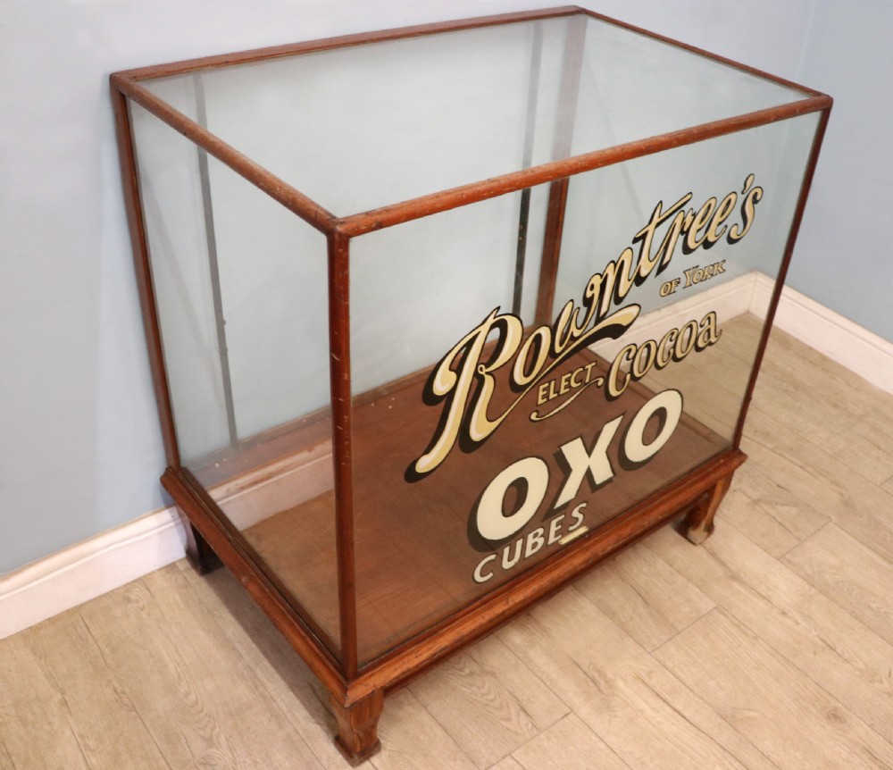 A glazed hardwood countertop display cabinet with sign-written lettering for Rowntrees Elect Cocoa and OXO Cubes on the front glass panel. View III