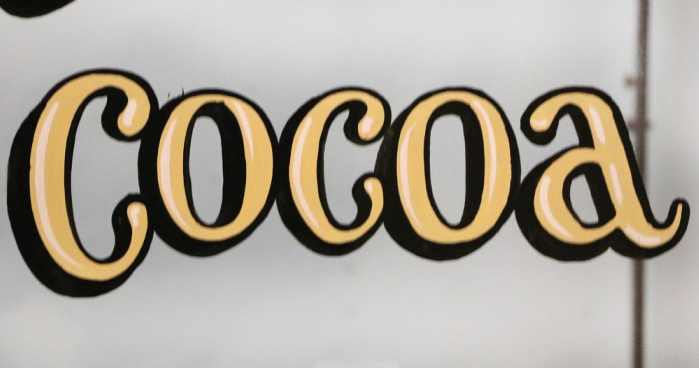 A glazed hardwood countertop display cabinet with sign-written lettering for Rowntrees Elect Cocoa and OXO Cubes on the front glass panel. View XIII