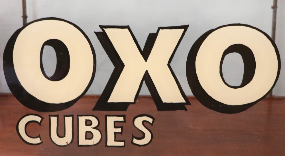 A glazed hardwood countertop display cabinet with sign-written lettering for Rowntrees Elect Cocoa and OXO Cubes on the front glass panel. View XIV