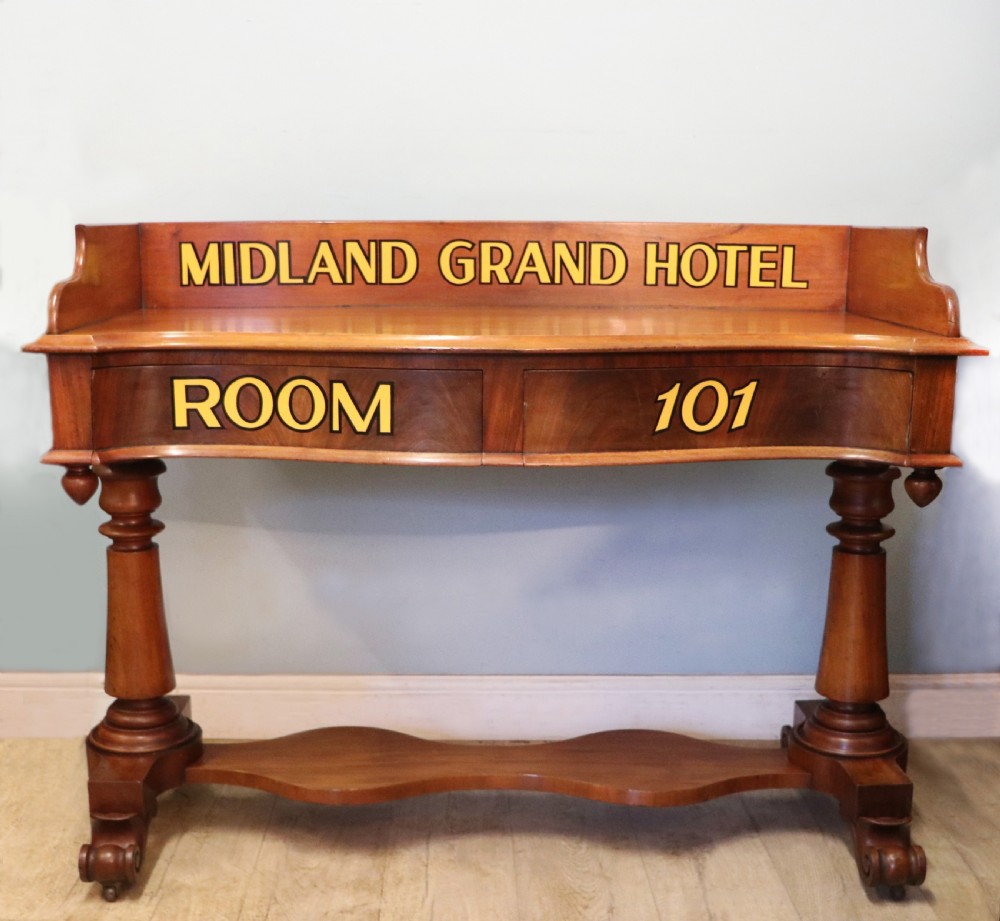 A Victorian mahogany console table with turned legs, a low gallery back, and yellow painted lettering reading Midland Grand Hotel Room 101.
