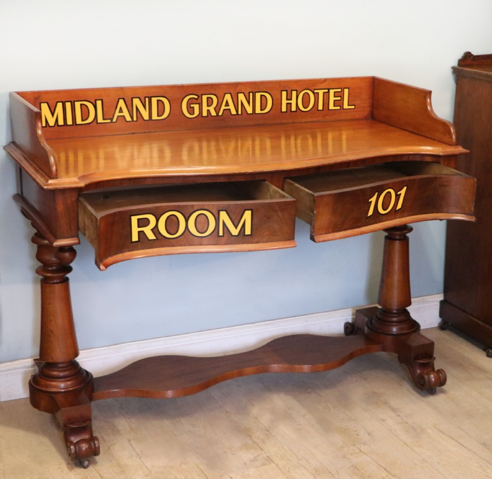 A Victorian mahogany console table with turned legs, a low gallery back, and yellow painted lettering reading Midland Grand Hotel Room 101. View IV