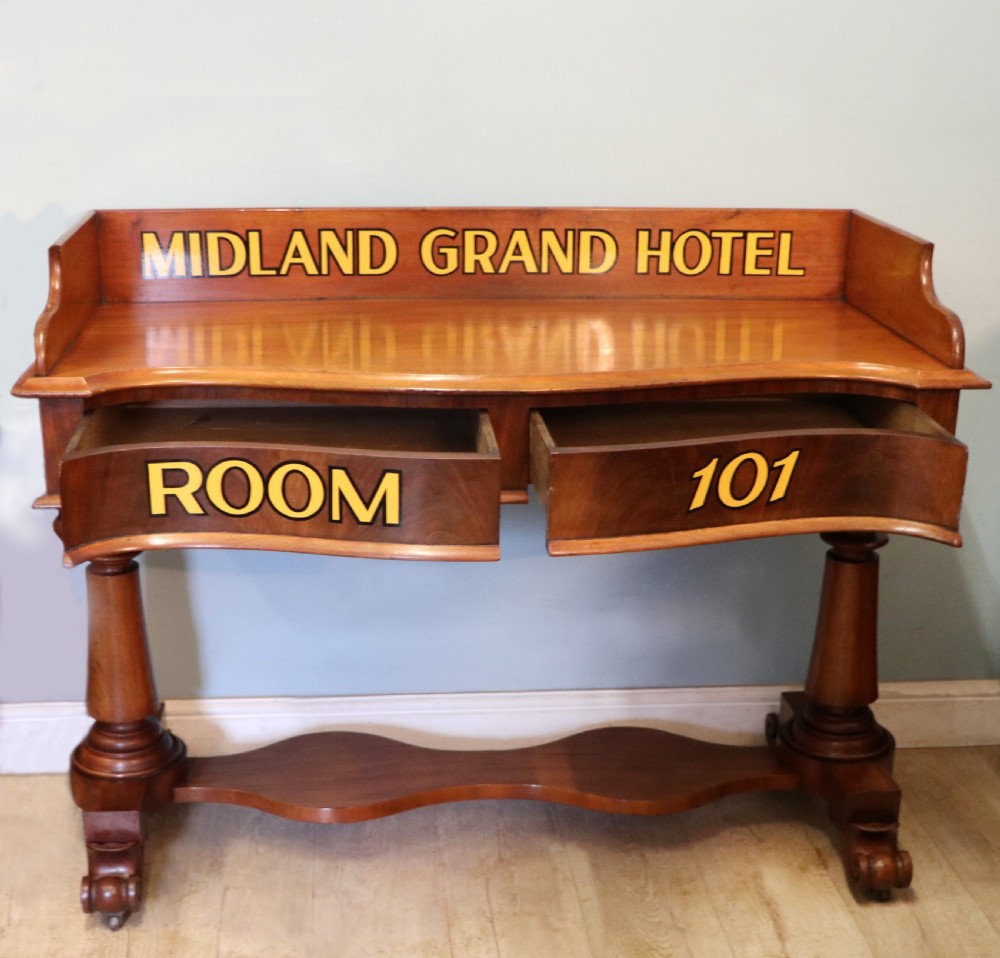 A Victorian mahogany console table with turned legs, a low gallery back, and yellow painted lettering reading Midland Grand Hotel Room 101. View V