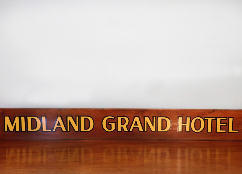 A Victorian mahogany console table with turned legs, a low gallery back, and yellow painted lettering reading Midland Grand Hotel Room 101. View VIII