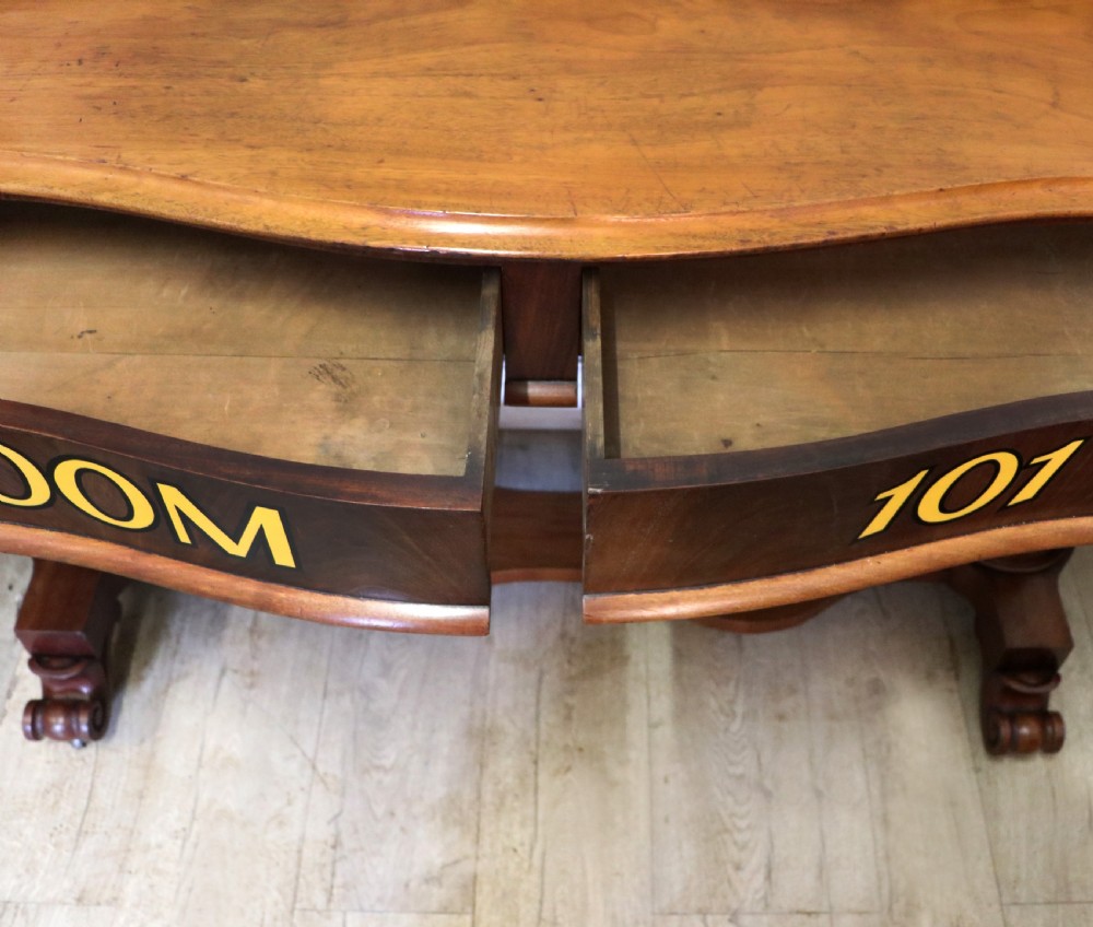 A Victorian mahogany console table with turned legs, a low gallery back, and yellow painted lettering reading Midland Grand Hotel Room 101. View XIX