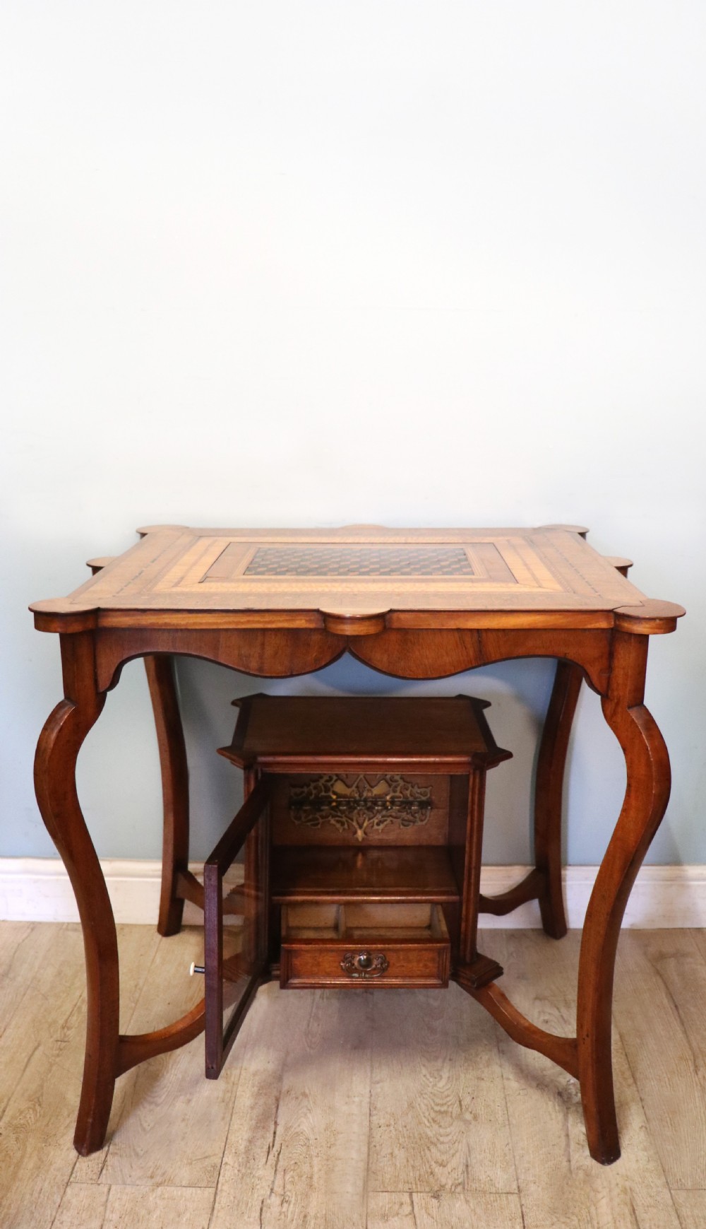 A late Victorian wooden occasional table featuring a geometric parquetry inlaid top, slender cabriole legs, and a lower glazed smokers cabinet. View III