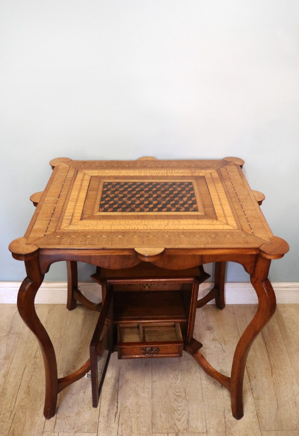 A late Victorian wooden occasional table featuring a geometric parquetry inlaid top, slender cabriole legs, and a lower glazed smokers cabinet. View IV