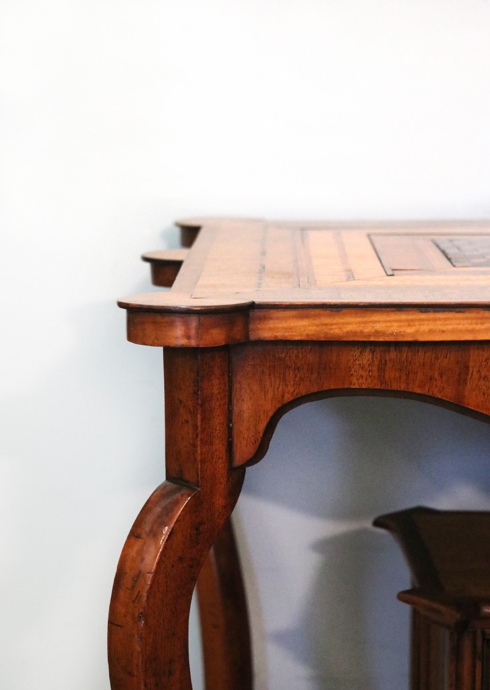 A late Victorian wooden occasional table featuring a geometric parquetry inlaid top, slender cabriole legs, and a lower glazed smokers cabinet. View VIII