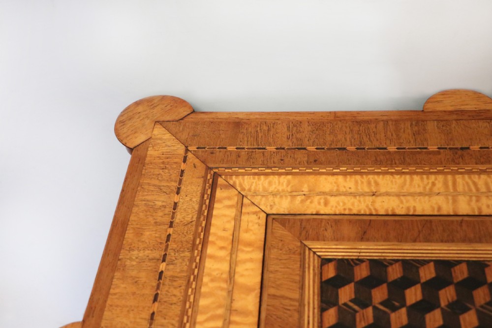 A late Victorian wooden occasional table featuring a geometric parquetry inlaid top, slender cabriole legs, and a lower glazed smokers cabinet. View IX