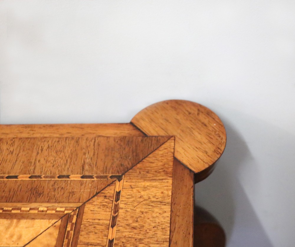 A late Victorian wooden occasional table featuring a geometric parquetry inlaid top, slender cabriole legs, and a lower glazed smokers cabinet. View XV