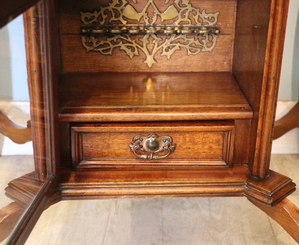 A late Victorian wooden occasional table featuring a geometric parquetry inlaid top, slender cabriole legs, and a lower glazed smokers cabinet. View XXI