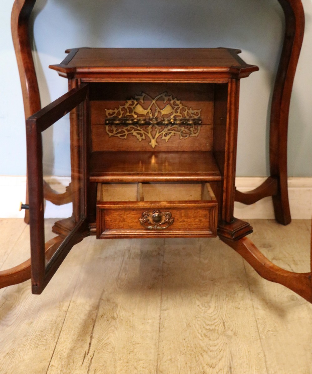 A late Victorian wooden occasional table featuring a geometric parquetry inlaid top, slender cabriole legs, and a lower glazed smokers cabinet. View XXII