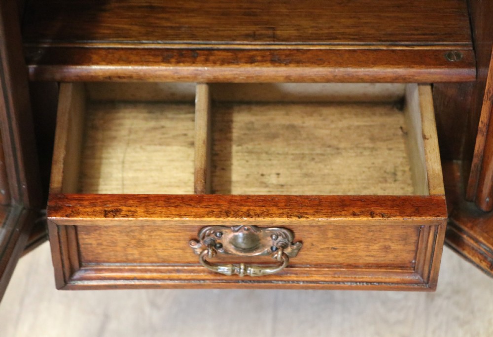 A late Victorian wooden occasional table featuring a geometric parquetry inlaid top, slender cabriole legs, and a lower glazed smokers cabinet. View XXV