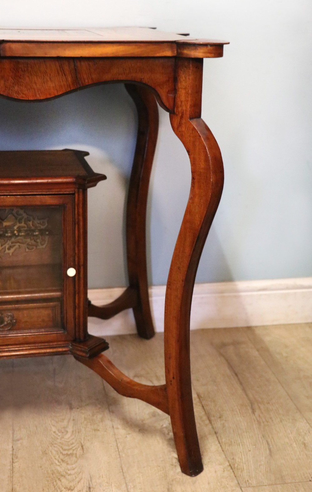A late Victorian wooden occasional table featuring a geometric parquetry inlaid top, slender cabriole legs, and a lower glazed smokers cabinet. View XXVI