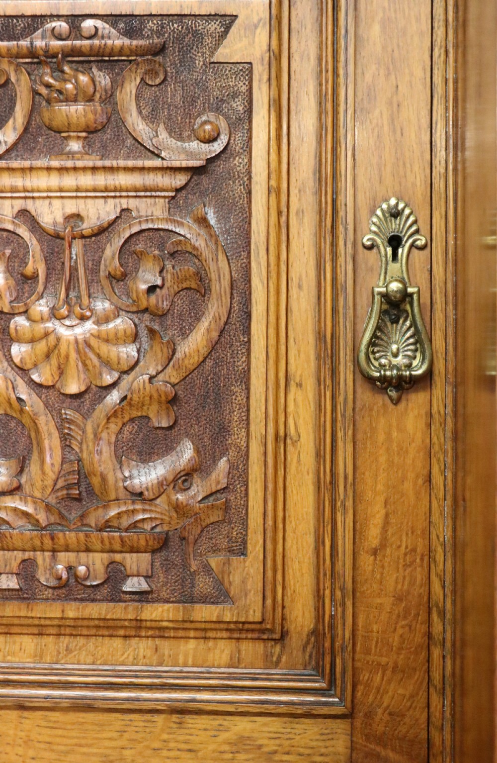 A late nineteenth-century American walnut compendium wardrobe featuring a full-length mirrored door, carved timber motif panel, open side shelving, brass handles, and integrated drawers. View XII
