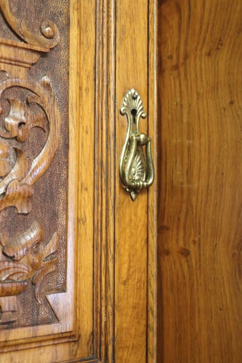 A late nineteenth-century American walnut compendium wardrobe featuring a full-length mirrored door, carved timber motif panel, open side shelving, brass handles, and integrated drawers. View XIII