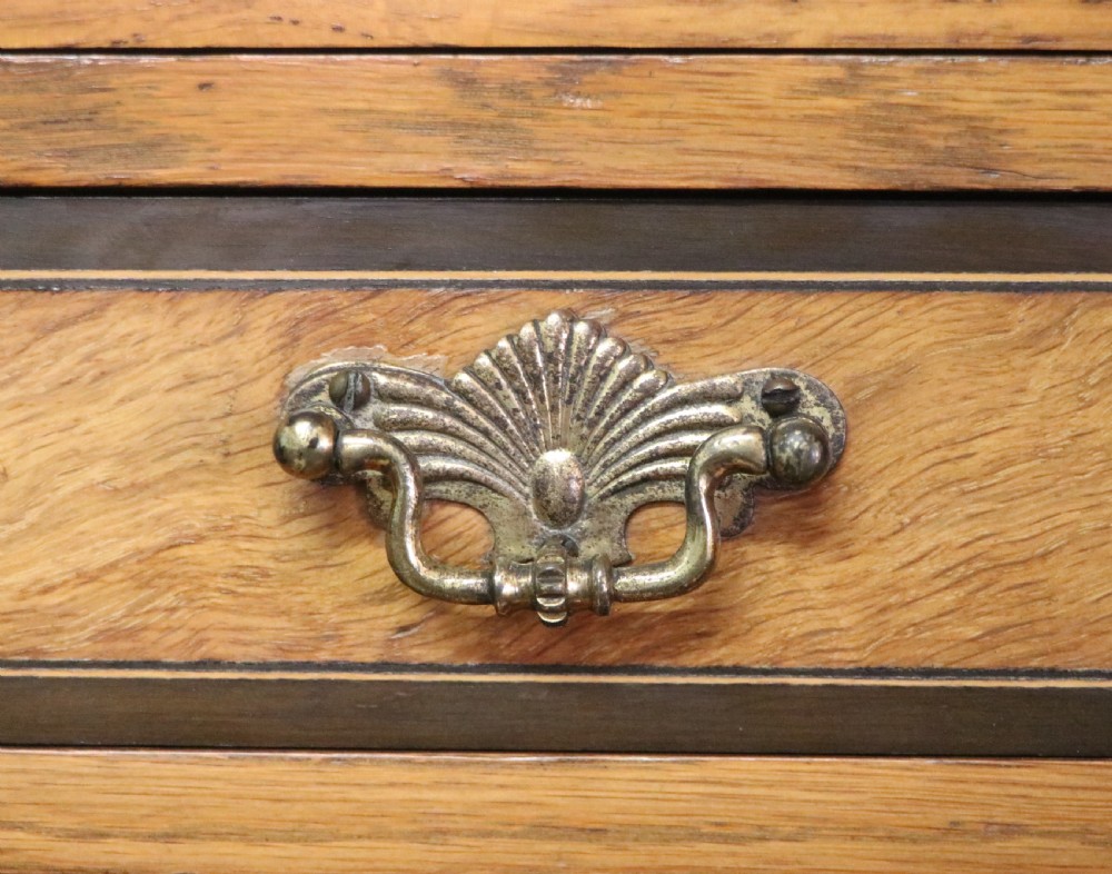 A late nineteenth-century American walnut compendium wardrobe featuring a full-length mirrored door, carved timber motif panel, open side shelving, brass handles, and integrated drawers. View XXI