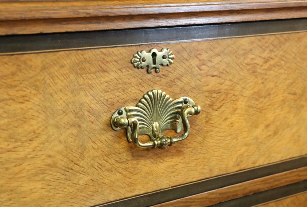 A late nineteenth-century American walnut compendium wardrobe featuring a full-length mirrored door, carved timber motif panel, open side shelving, brass handles, and integrated drawers. View XXII