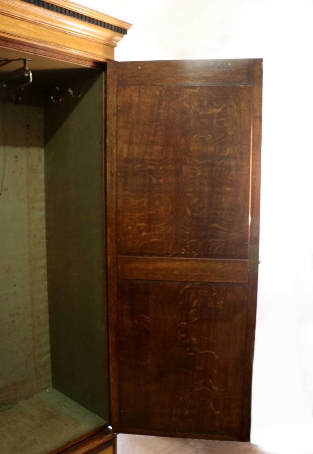 A late nineteenth-century American walnut compendium wardrobe featuring a full-length mirrored door, carved timber motif panel, open side shelving, brass handles, and integrated drawers. View XXX