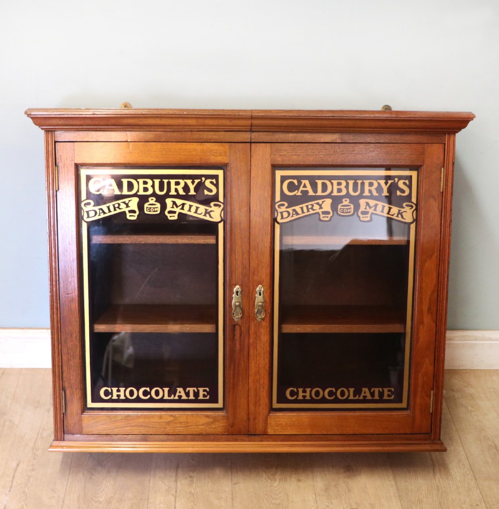 A superb late Victorian walnut framed wall cabinet, later sign written for Cadbury chocolate.