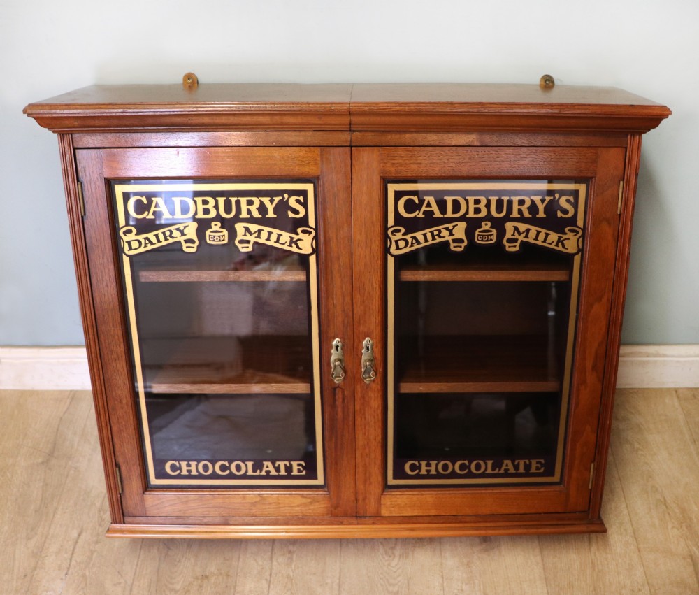A superb late Victorian walnut framed wall cabinet, later sign written for Cadbury chocolate. View II