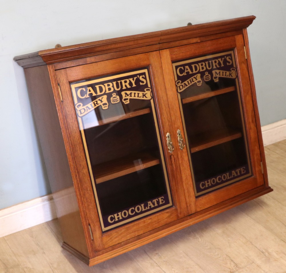 A superb late Victorian walnut framed wall cabinet, later sign written for Cadbury chocolate. View VI