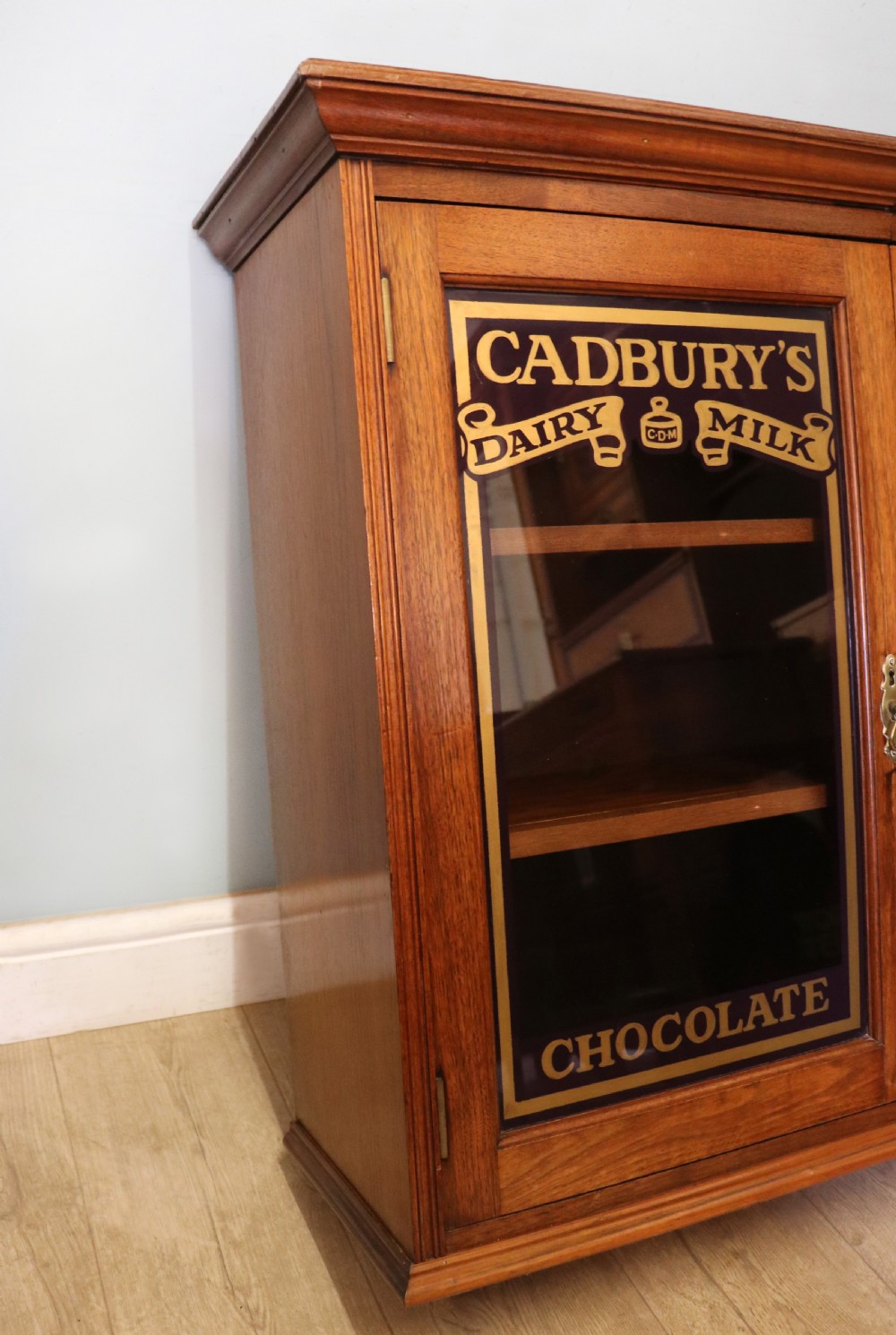 A superb late Victorian walnut framed wall cabinet, later sign written for Cadbury chocolate. View VIII