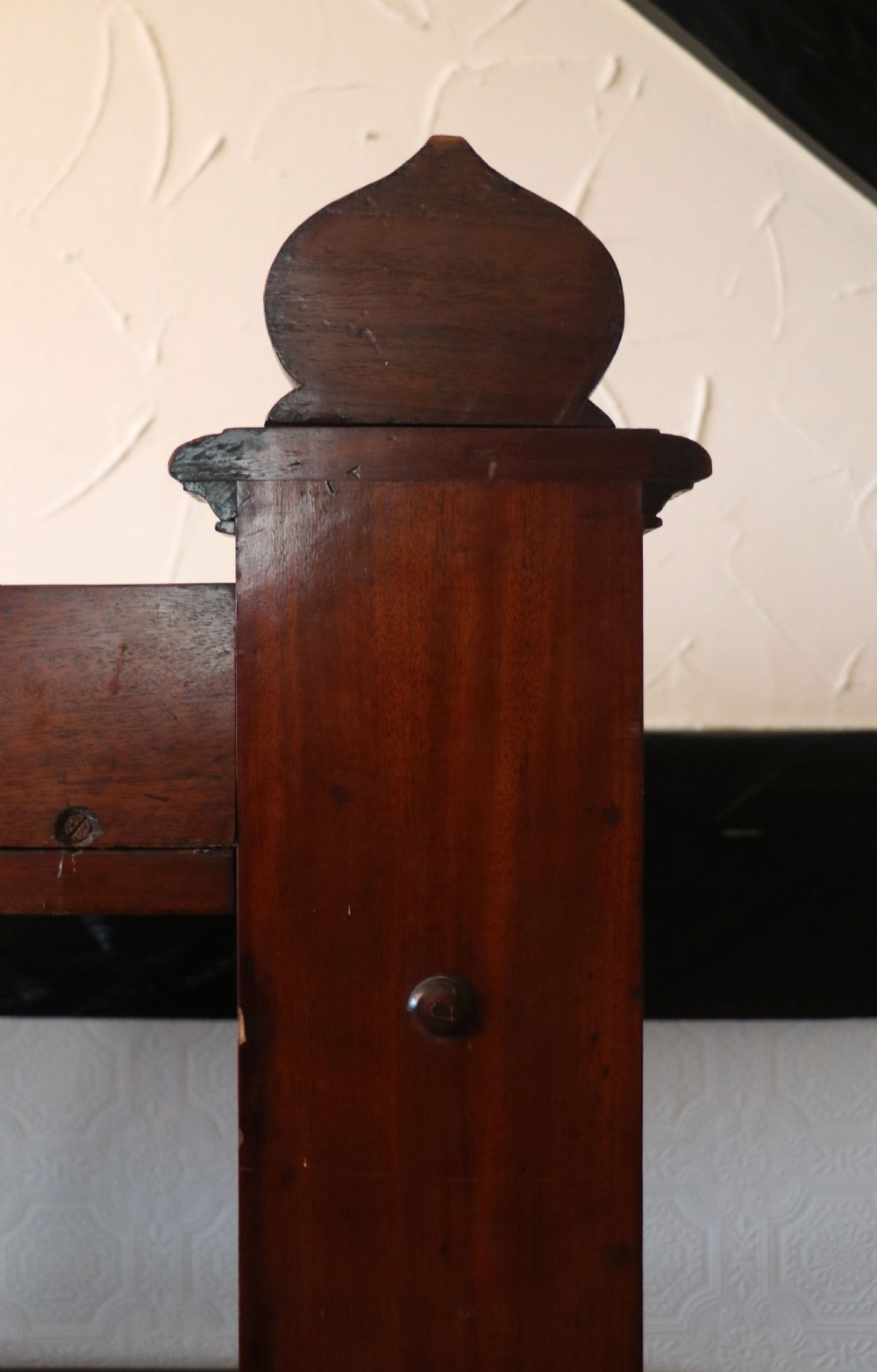 A Victorian mahogany three-tiered dumb waiter featuring carved decorative pediments, supporting brackets, lower drawers, and ceramic castors. View XVI