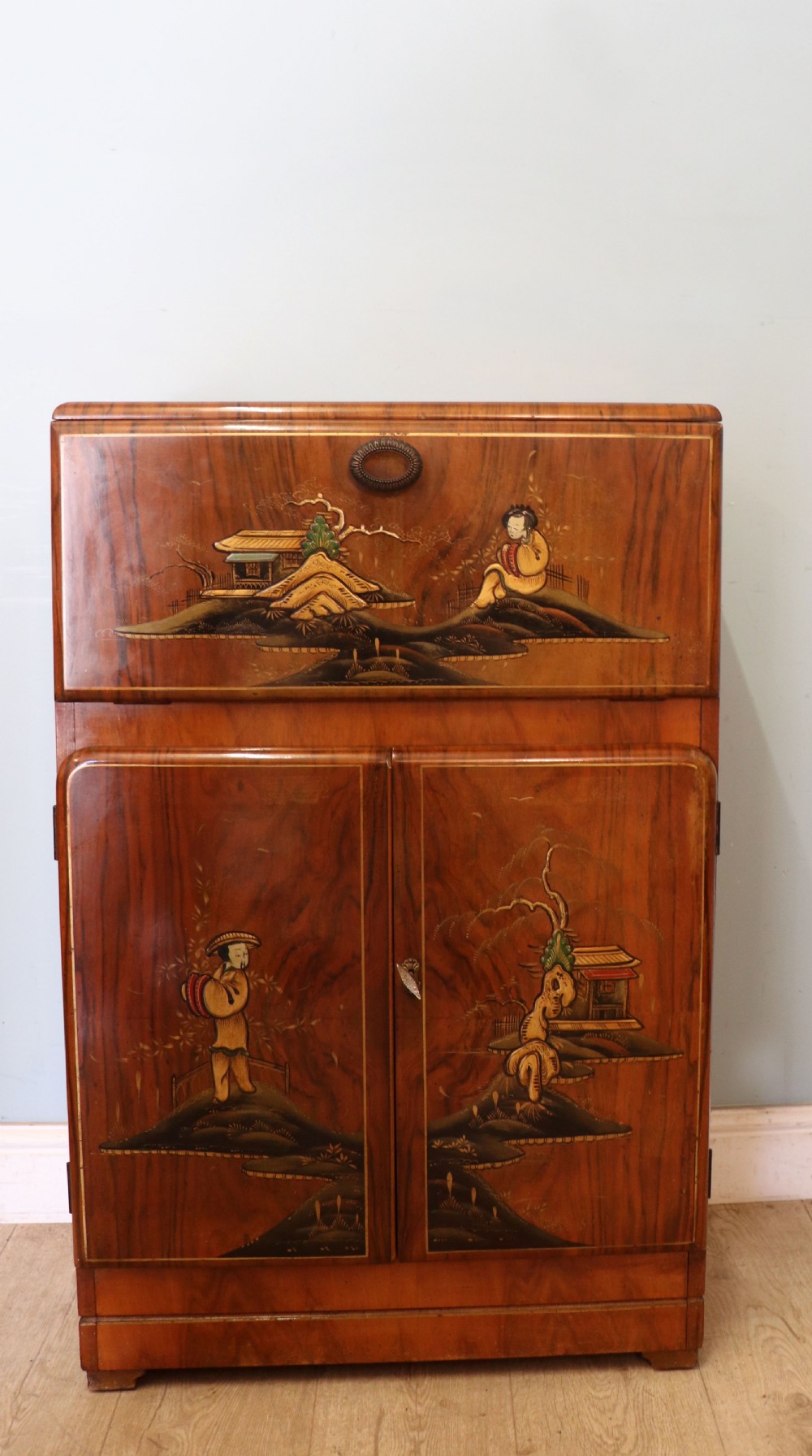 A wonderfully stylish piece of retro furniture An Art Deco walnut and chinoiserie-decorated cabinet by Rivington.  View II