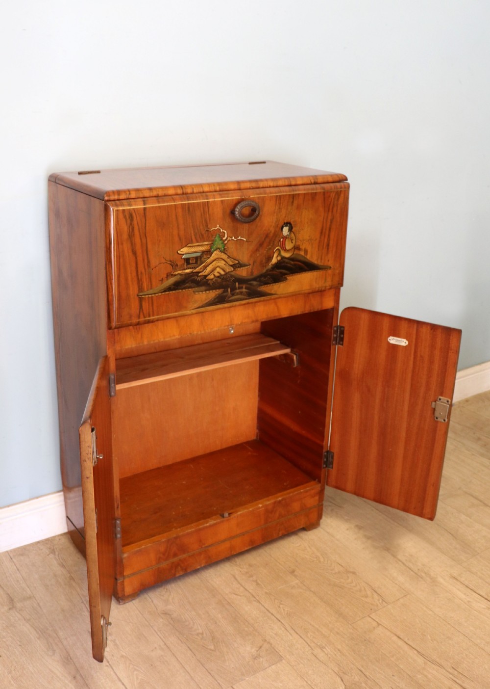 A wonderfully stylish piece of retro furniture An Art Deco walnut and chinoiserie-decorated cabinet by Rivington.  View V
