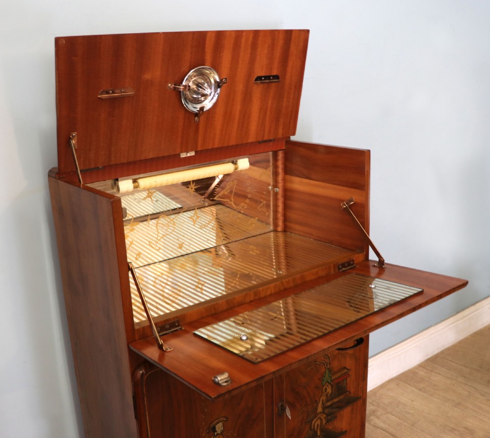 A wonderfully stylish piece of retro furniture An Art Deco walnut and chinoiserie-decorated cabinet by Rivington.  View XIV