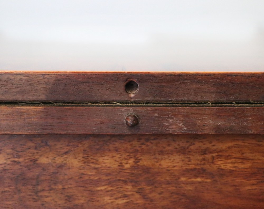 A late Georgian dark rosewood card table featuring an open fold-over green baize top supported on a spiral-carved pedestal and splayed legs with brass paw castors. View XV
