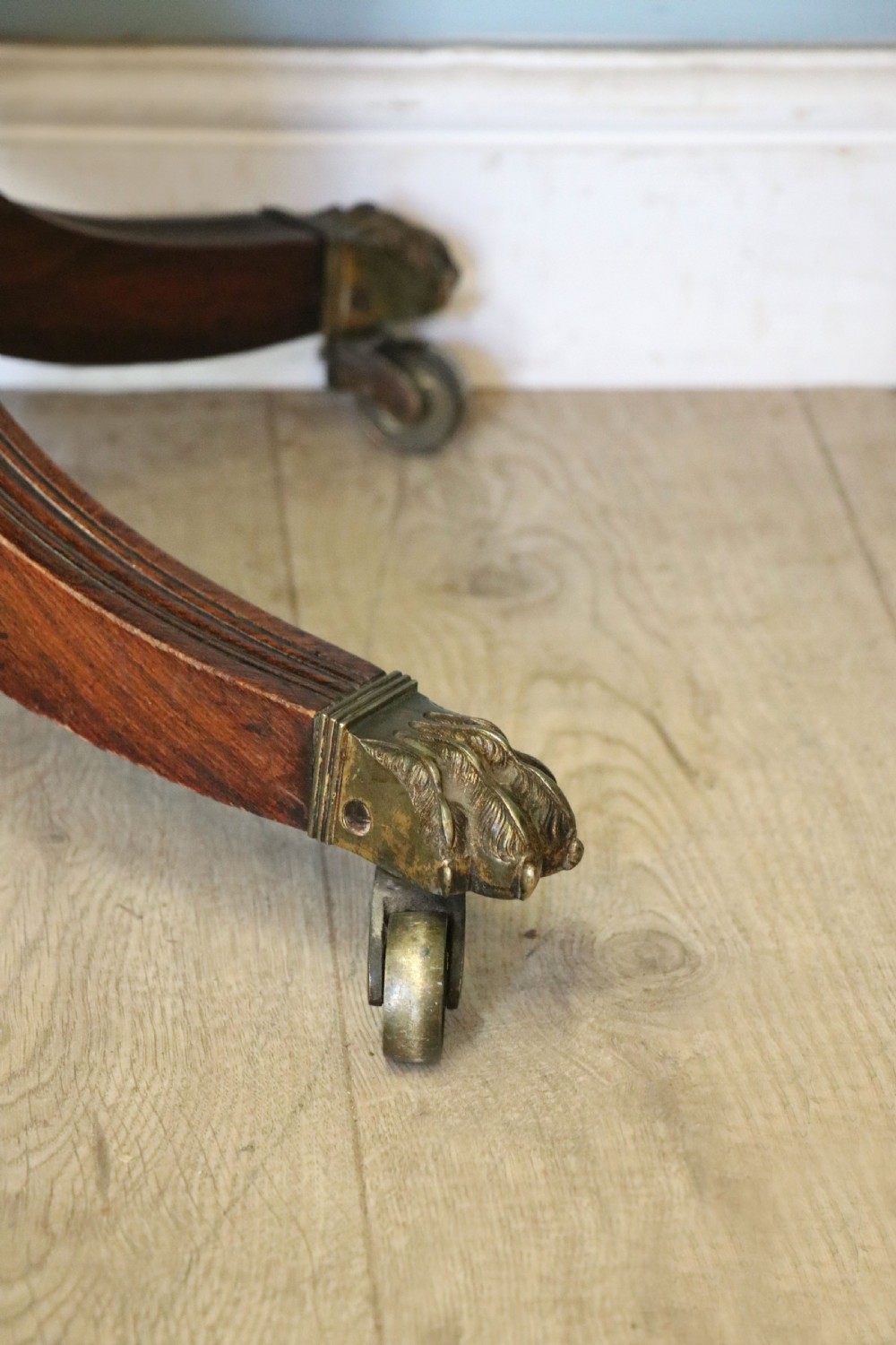 A late Georgian dark rosewood card table featuring an open fold-over green baize top supported on a spiral-carved pedestal and splayed legs with brass paw castors. View XIX