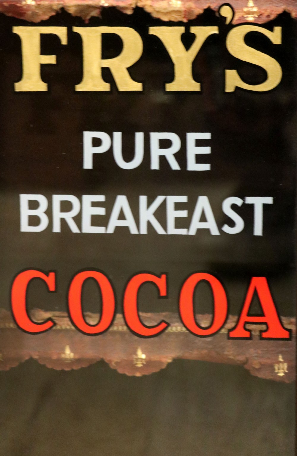 A dark mahogany Victorian display cabinet featuring glazed doors painted with Frys Cocoa and Chocolate advertising typography. View II