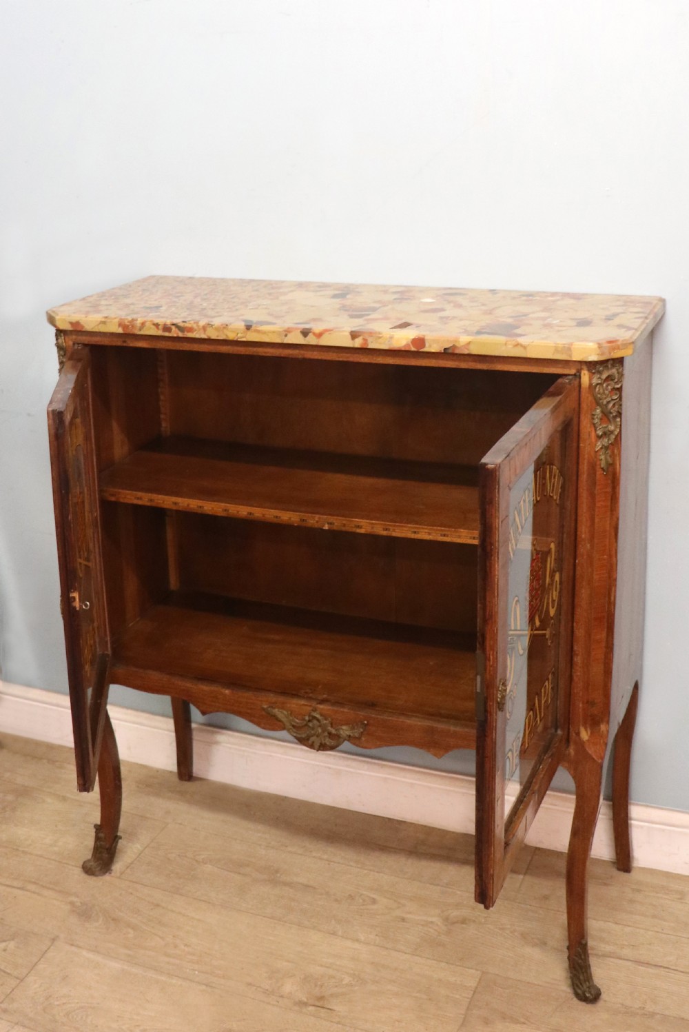 An early 20th-century French wooden display cabinet featuring a marble top, cabriole legs, gilt bronze mounts, and glass doors with hand-painted Chateauneuf-du-Pape lettering. View V