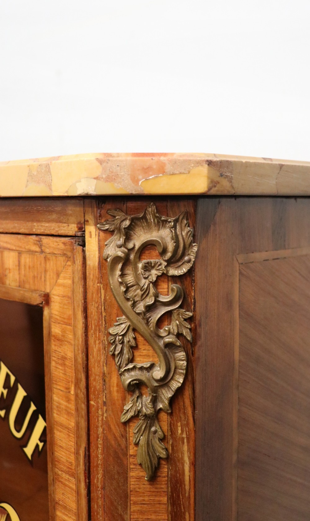 An early 20th-century French wooden display cabinet featuring a marble top, cabriole legs, gilt bronze mounts, and glass doors with hand-painted Chateauneuf-du-Pape lettering. View XIV